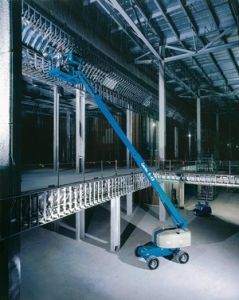 Genie straight boom lift being used in warehouse for high reach electrical work