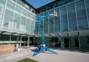 Genie TZ3420 Towable Boom Lift used to clean windows of commercial building