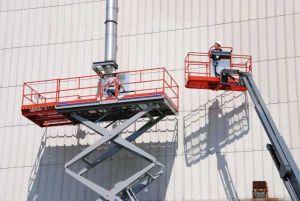 Skyjack Scissor lift and boom lift elevating men working on side of building