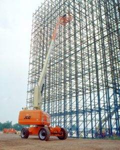 JLG Aerial work platform extended next to tall building under construction