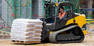 Compact Track Loader with Pallet Fork Attachment delivering construction supplies